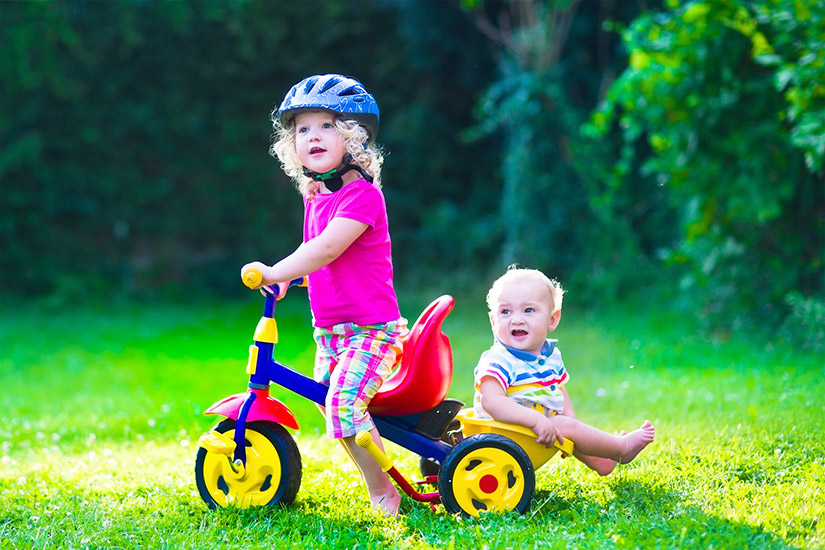 Kids on bike playing on green lawn